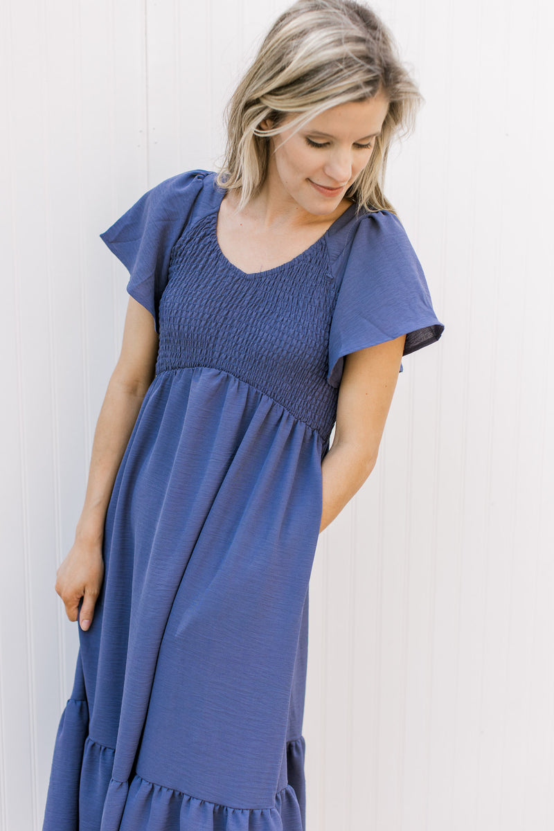 Model wearing a v-neck midi with a smocked bodice and flutter short sleeves.