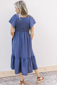 Back view of Model wearing a v-neck midi with a smocked bodice and flutter short sleeves.