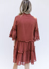 Back view of Model wearing a brick colored above the knee dress with pockets and butterfly sleeves. 