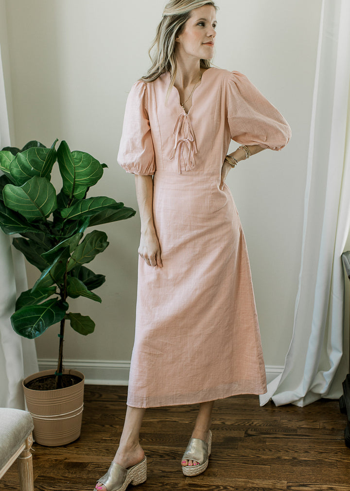 Model wearing wedges and a blush midi with bubble sleeves, scalloped v-neck and cinched waist.
