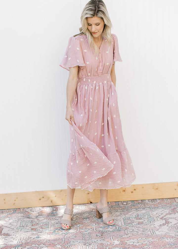 Model wearing heels and a pink v-neck midi with white flowers, elastic waist and short sleeves. 