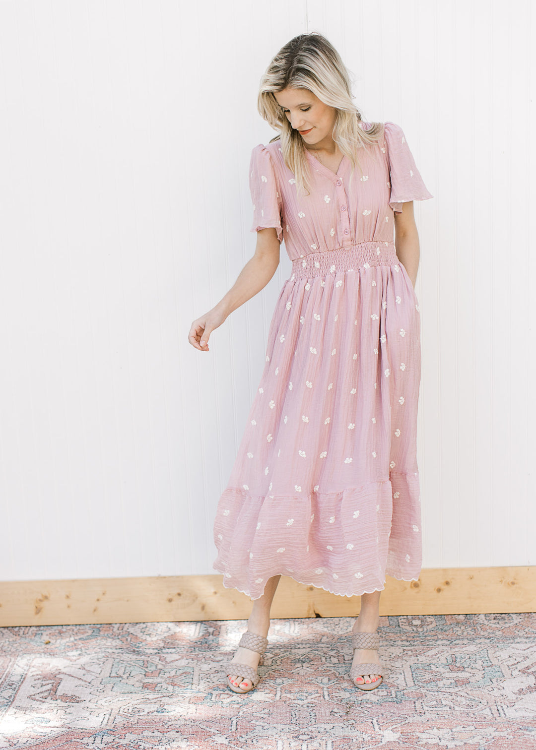 Model wearing a flowy pink gauze midi with short sleeves, smocked waist and a v-neck. 