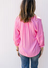 Back view of a bright pink top with 3/4 sleeves and ruffle at neck and sleeve. 