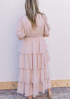 Back view of Model wearing a pale pink maxi with ditsy floral, ruffle tiers and bubble short sleeve.