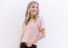 Model wearing black jeans and a pink sparkle top with short sleeves and a slightly cropped fit.