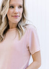 Model wearing a pink lightweight sparkle top with short sleeves and a slightly cropped fit.