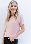 Model wearing a pink sparkle top with a round neck, short sleeves and a slightly cropped fit.