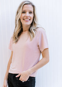 Model wearing a pink sparkle top with a round neck, short sleeves and a slightly cropped fit.