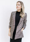 Model wearing a brown plaid blazer with 3/4 tacked sleeves and classic detailing. 