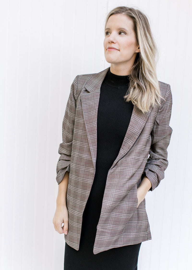 Model wearing a brown plaid blazer with 3/4 tacked sleeves and classic detailing. 