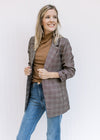 Model wearing jean with a black top and a brown plaid blazer with 3/4 tacked sleeves. 