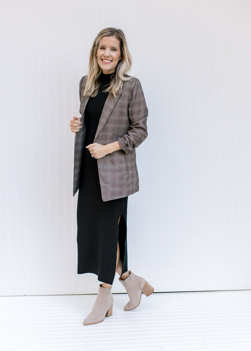 Model wearing a black maxi with a brown plaid blazer with 3/4 tacked sleeves and classic detailing. 