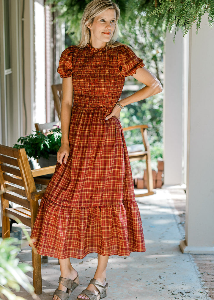 Model wearing sandals and a fall plaid midi with a smocked bodice and bubble short sleeves. 