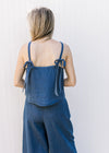Back view of Model wearing a blue set with a spaghetti strap top with faux tie and wide leg bottoms.