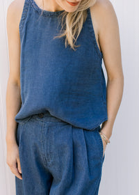 Close up of pleating detail, pockets and button closure on the pants of a matching set. 
