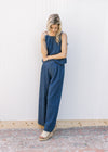Model wearing a denim blue set with a spaghetti strap top with faux tie and wide legs bottoms.