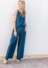 Model wearing sandals and a denim blue set with a spaghetti strap top wide legs bottoms.