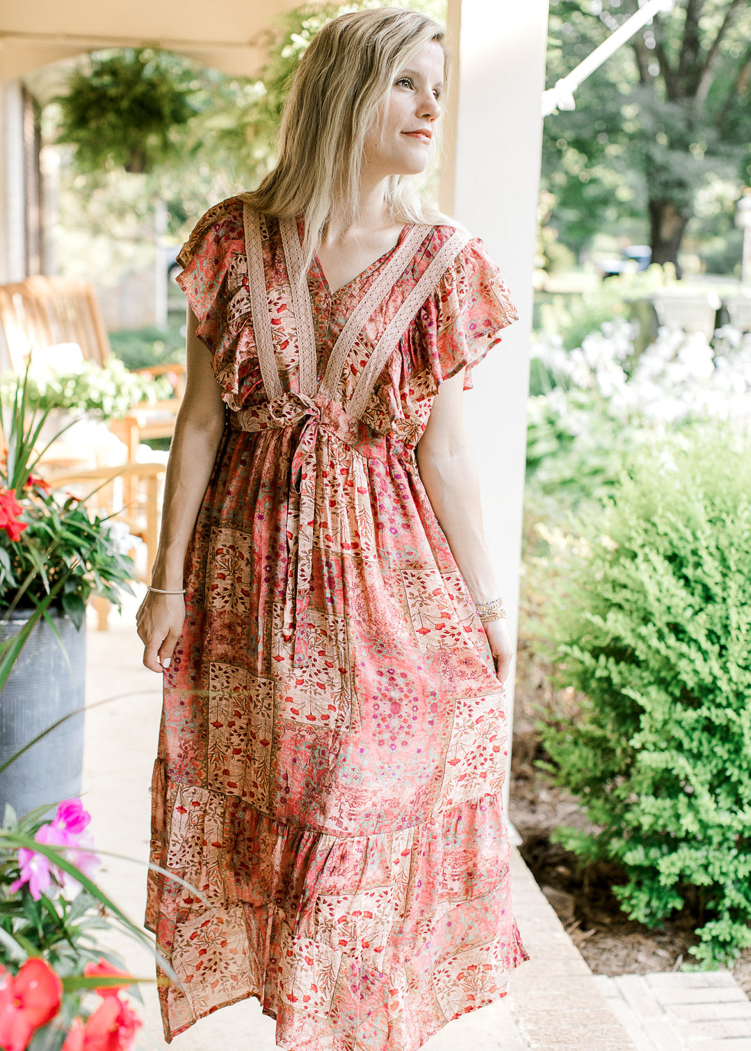 Model wearing a maroon midi with patchwork, flutter cap sleeves and tie waist. 