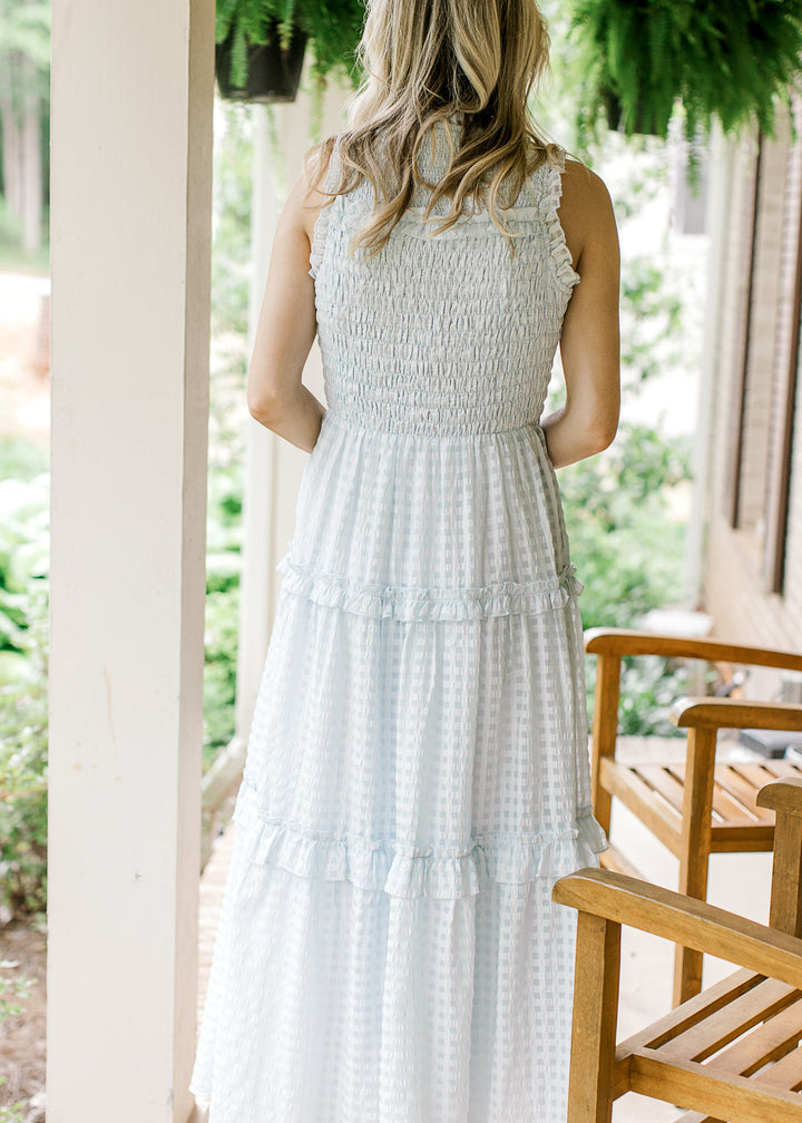 Back view of Model wearing a powder blue midi with a smocked bodice and tone on tone checks. 