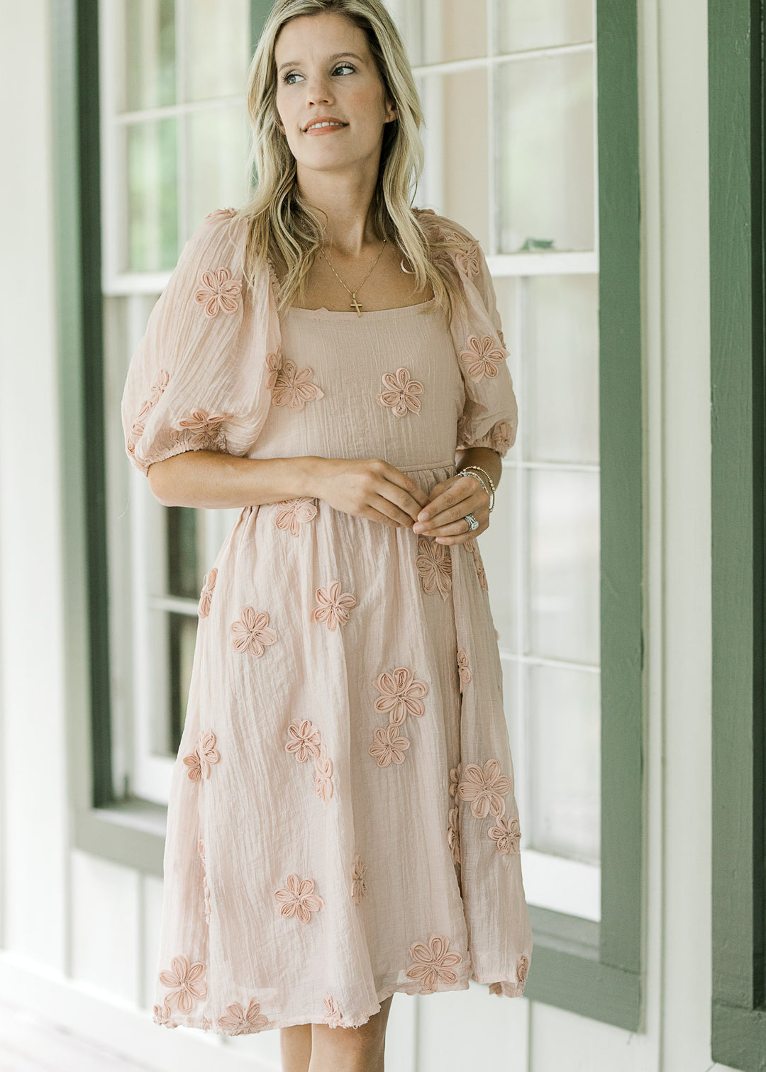 Model wearing a light pink dress with a square neck, elastic at waist and bubble short sleeves. 