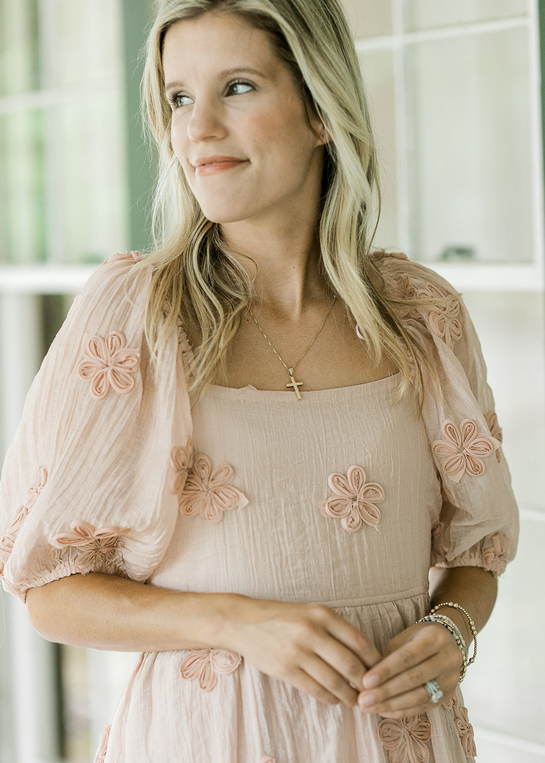 Close up of textured tulle flowers on a light pink dress with bubble short sleeves and square neck. 