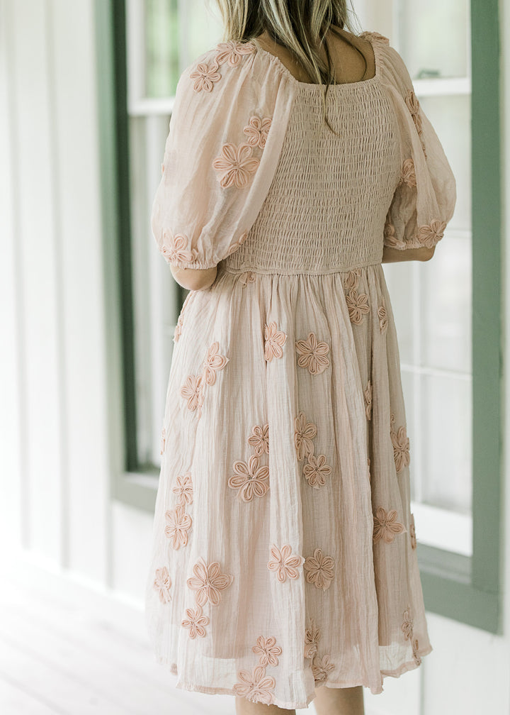 Back view of Model wearing a light pink dress with smocked back and bubble short sleeves. 