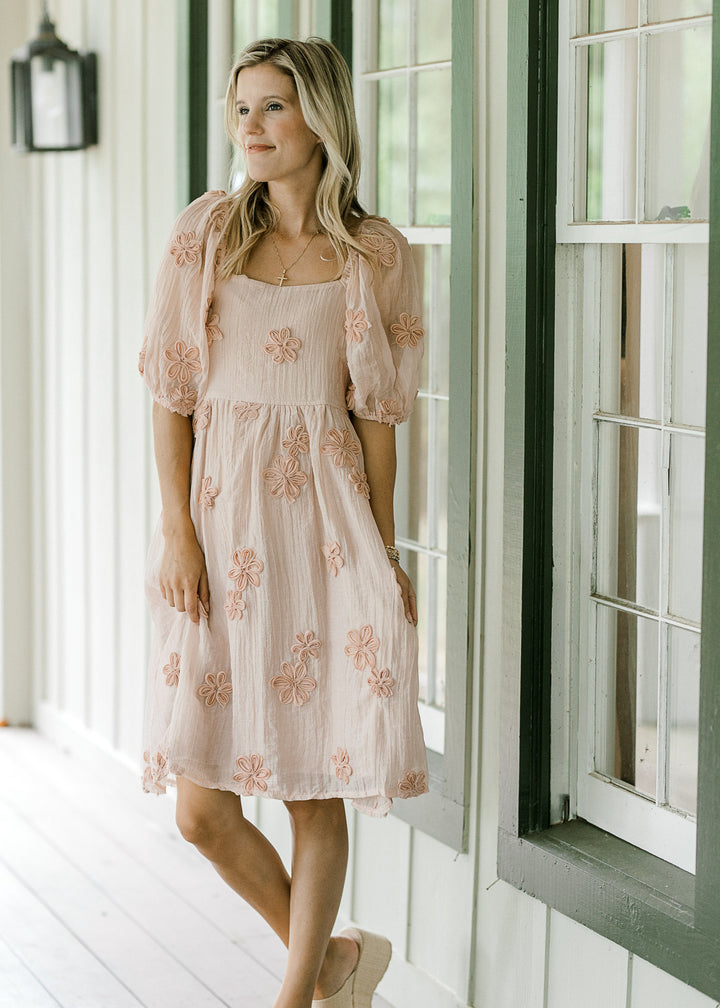 Model wearing wedges and a light pink dress with elastic at waist and bubble short sleeves. 