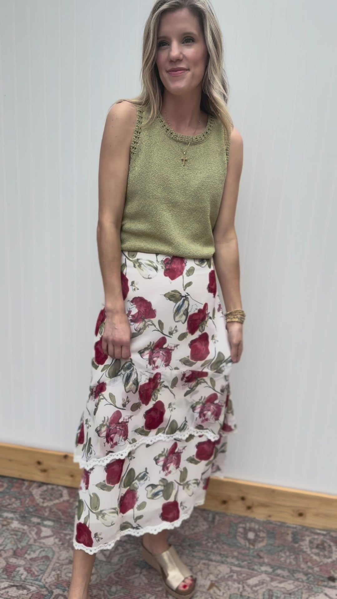 Video of Model wearing an ivory midi with red floral print, tiers with lace trim and a hidden zipper.