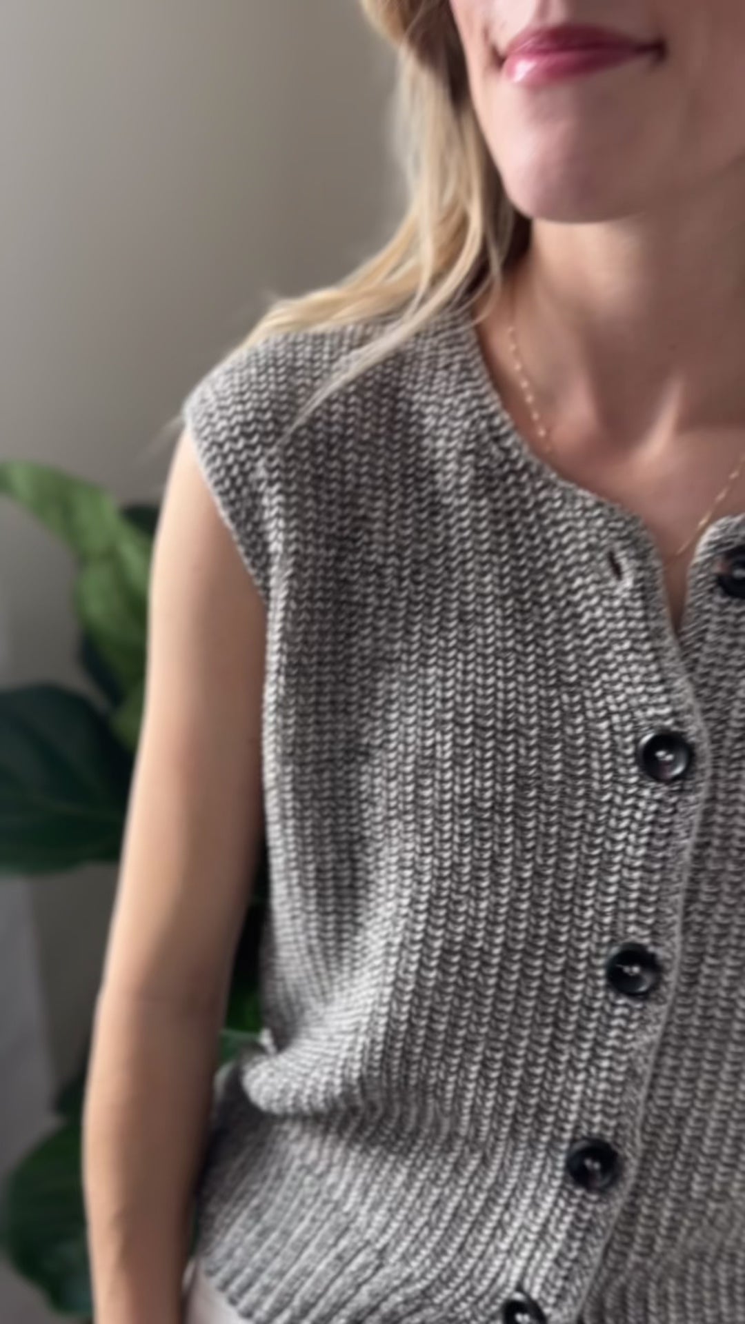 Video of Model wearing a Black and white marled cap sleeve sweater with a button front. 