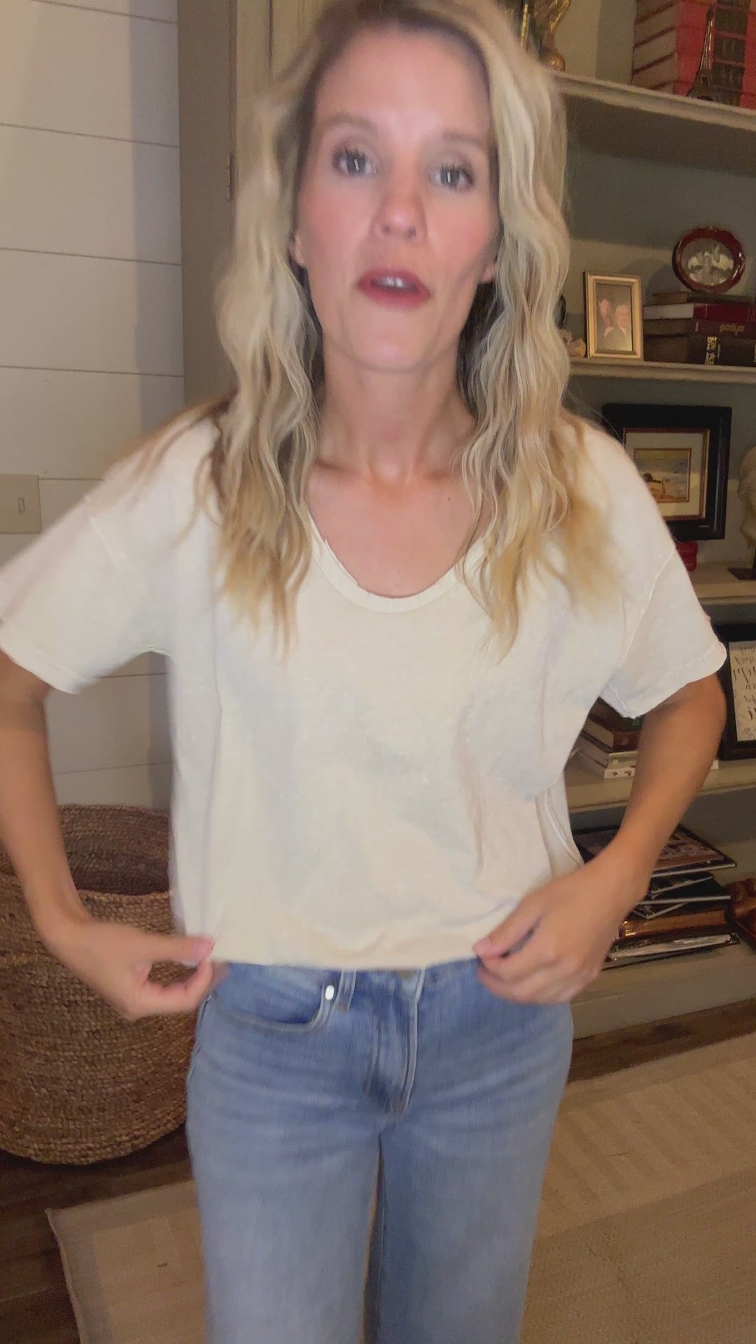 Video of Model wearing a v-neck oatmeal top with raw edges, short sleeves and a loose fit. 