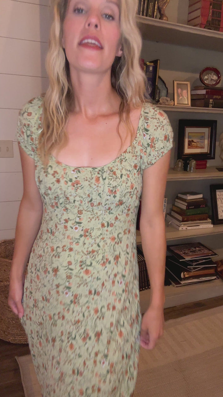 Video of Model wearing a soft olive-green maxi with floral print, round neck and short sleeves. 