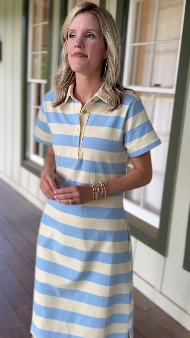 Video of Model wearing a pale yellow and blue striped knee length dress with a collar and short sleeves. 