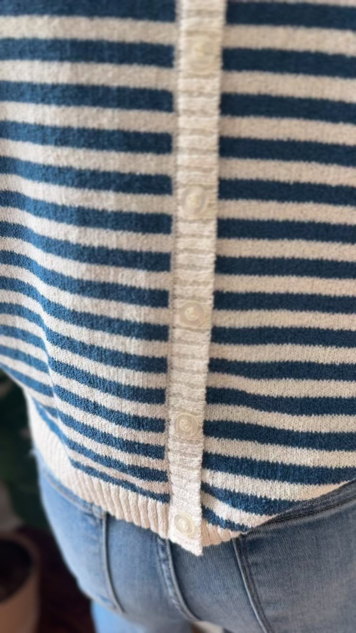 Video of Model wearing a blue and cream striped sweater with short sleeves and button down the back. 