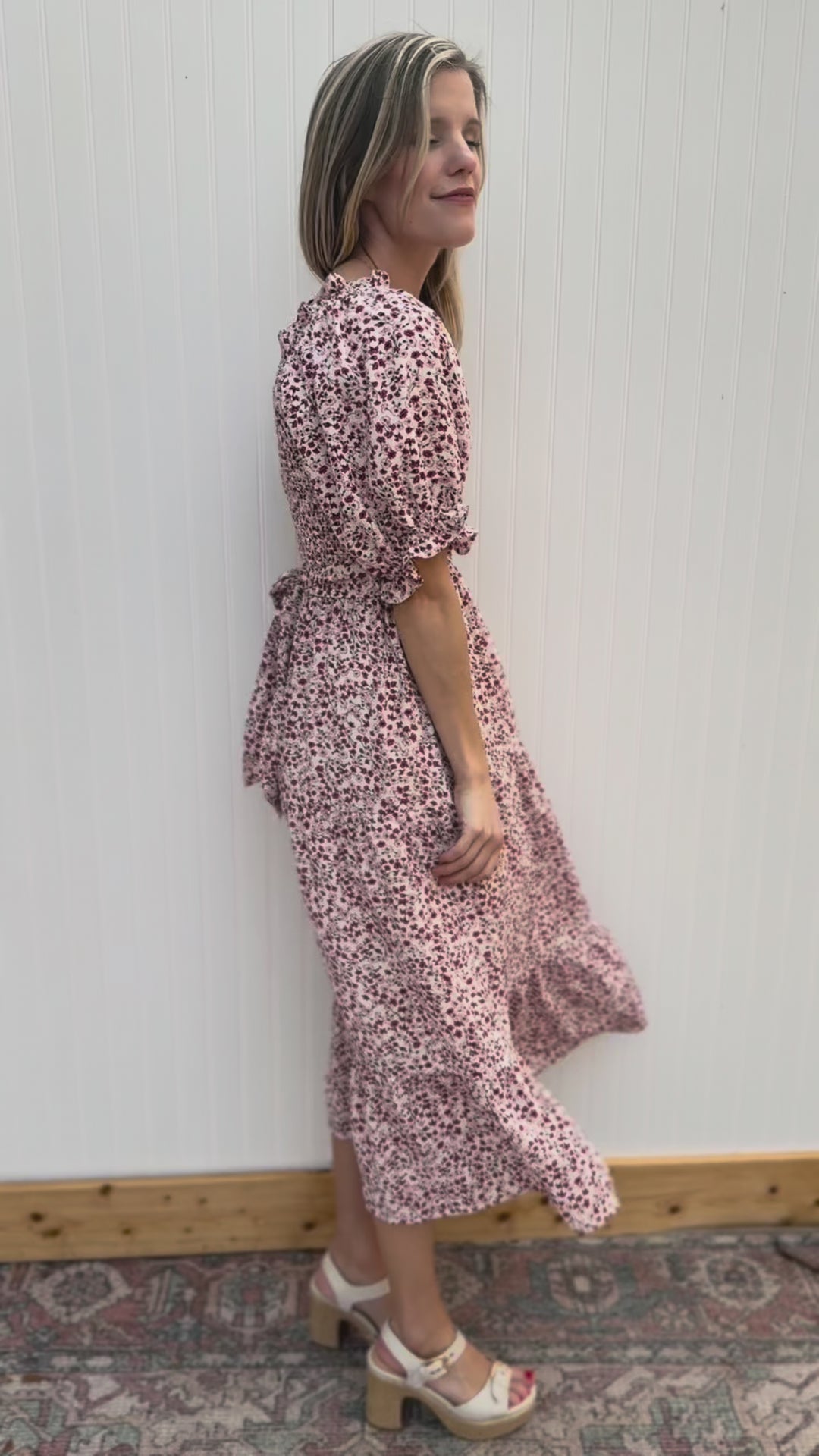 Video of Model wearing a cream midi with maroon and pink floral, smocked bodice and bubble short sleeves.