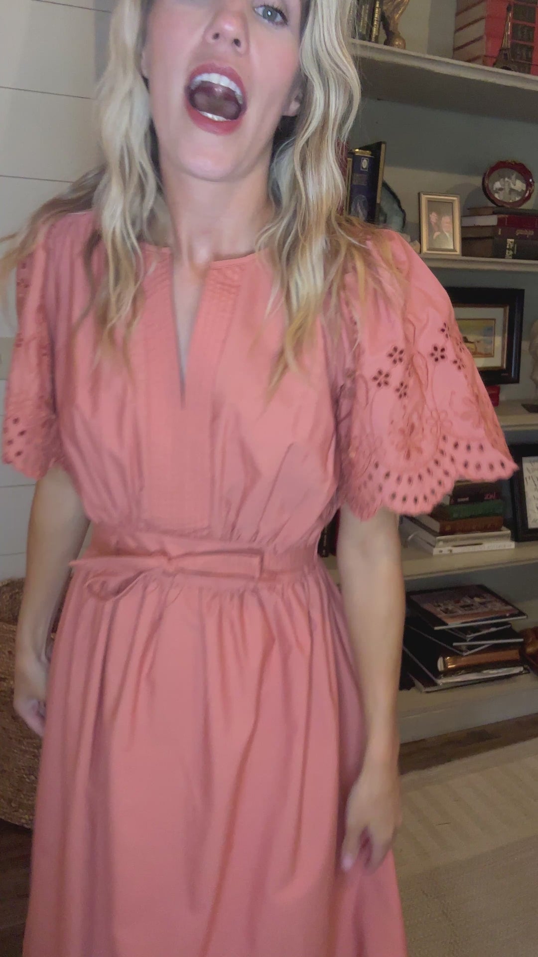 Video of Model wearing a warm rust midi with tone on tone eyelets, short sleeves, v-neck and tie front. 