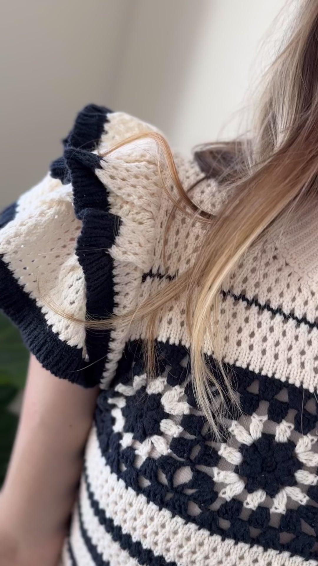 Video of Model wearing a cream skirt with attached crochet sweater top with black stripes and flutter sleeves.