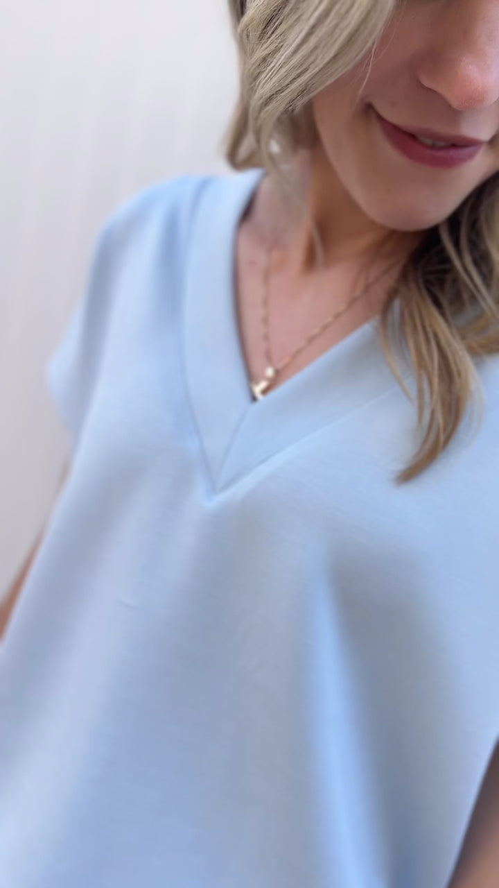 Video of Model wearing a baby blue set the top has a v-neck and short sleeves with wide leg bottoms.