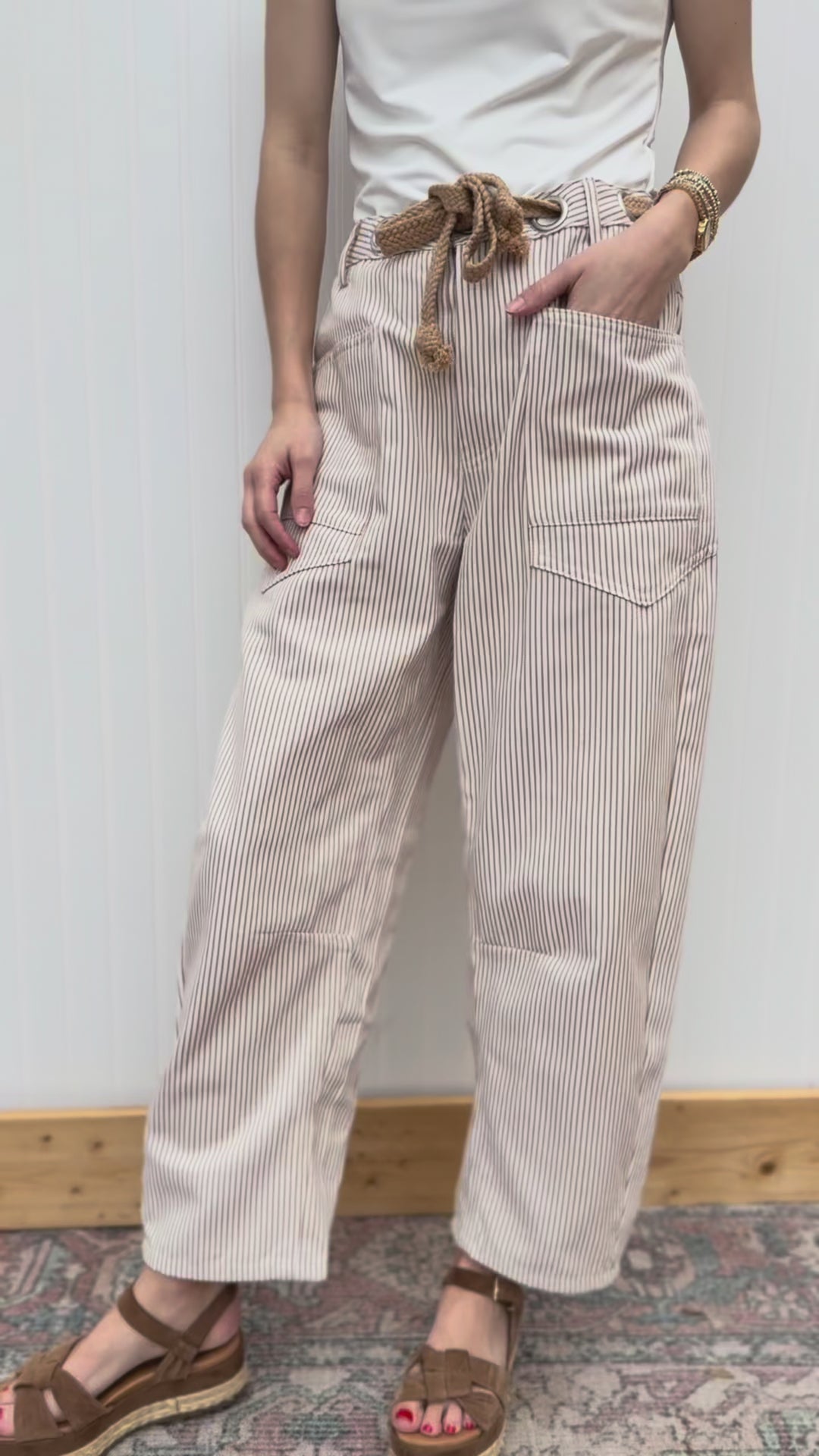 Video of Model wearing cream barrel leg pants with tan pinstripes, high waist and front patch pockets. 