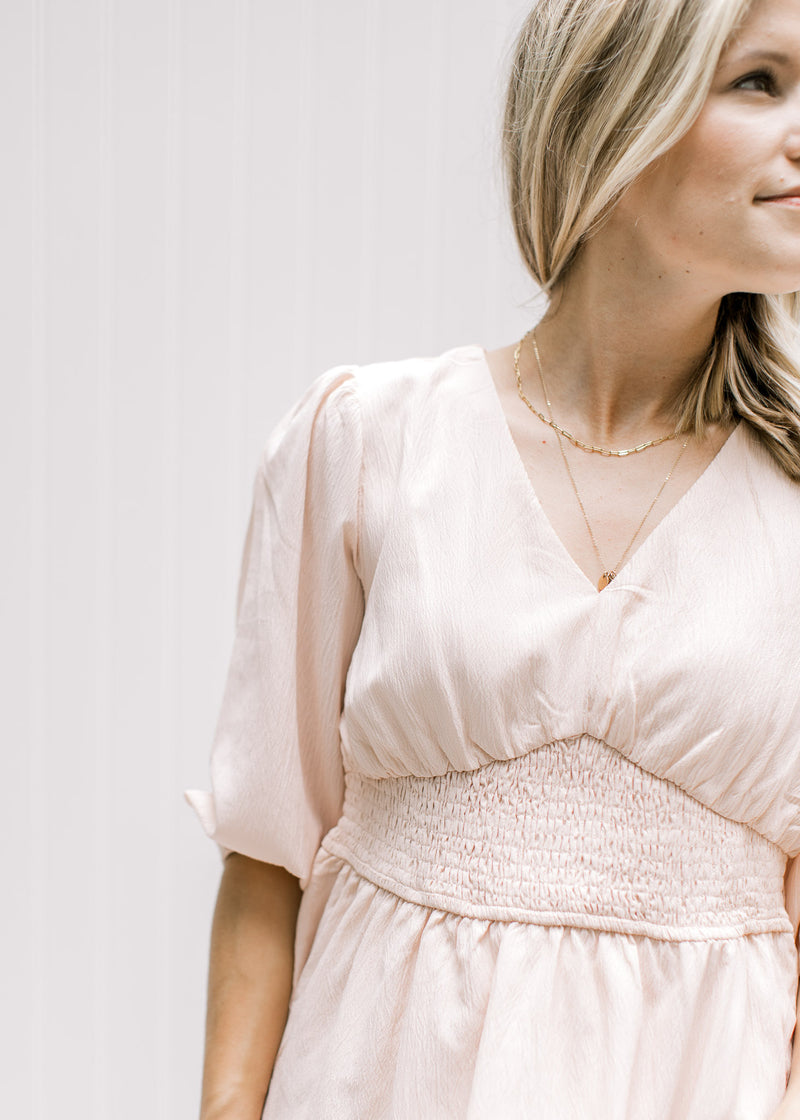 Close up of v-neck and cinched waist on a blush fully lined top with 3/4 bubble sleeves.  