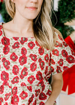 Close up of high square neck on a cream top with red poppy’s, a brocade fabric and short sleeves. 