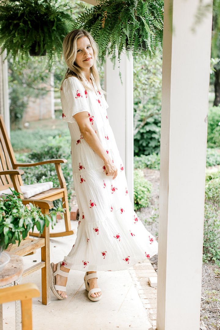 Model wearing a white maxi with red flowers, crinkle material, short sleeves and a v-neck. 