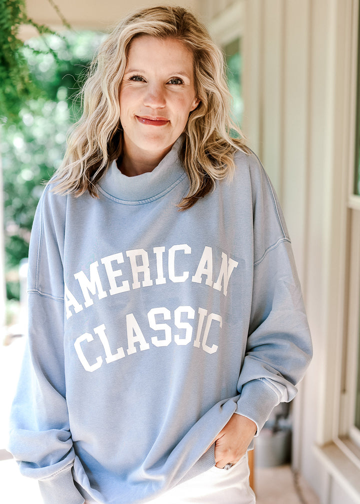 Model wearing a pale blue lightweight sweatshirt with white "American Classic" graphic on front.