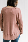 Back view of Model wearing a wine colored ribbed top with long sleeves and a round neck.