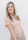 Model wearing a ribbed oatmeal colored top with short sleeves and a round neck. 