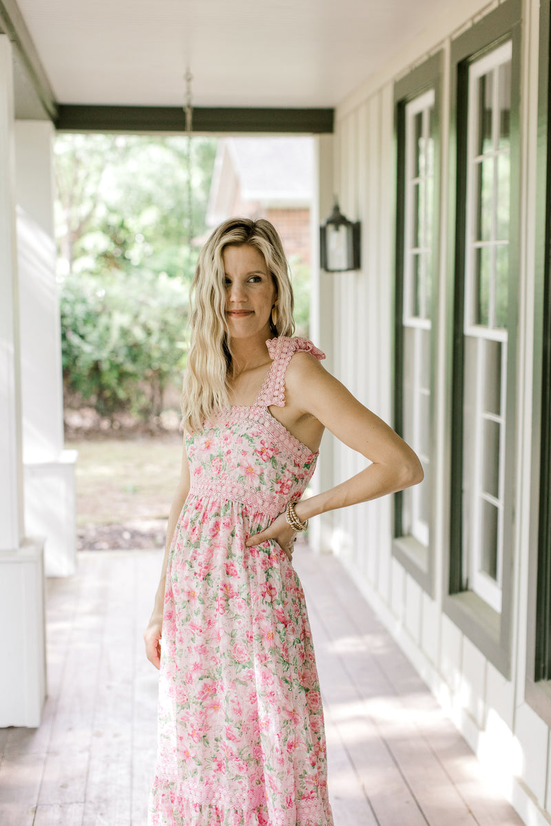 Model wearing a pink dress with pink and green flower, contrasting detail and tie spaghetti straps.