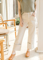 Model wearing mules and light khaki cargo pants with a high waist and wide legs.