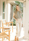 Model wearing a green sweater, mules and light khaki cargo jeans with  wide legs. 