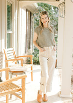 Model wearing a green sweater, mules and light khaki cargo jeans with  wide legs. 