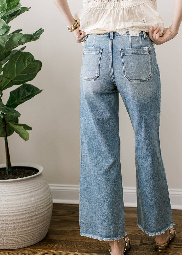 Back view of Model wearing a medium/light wash ankle jeans with high rise, wide leg fit.