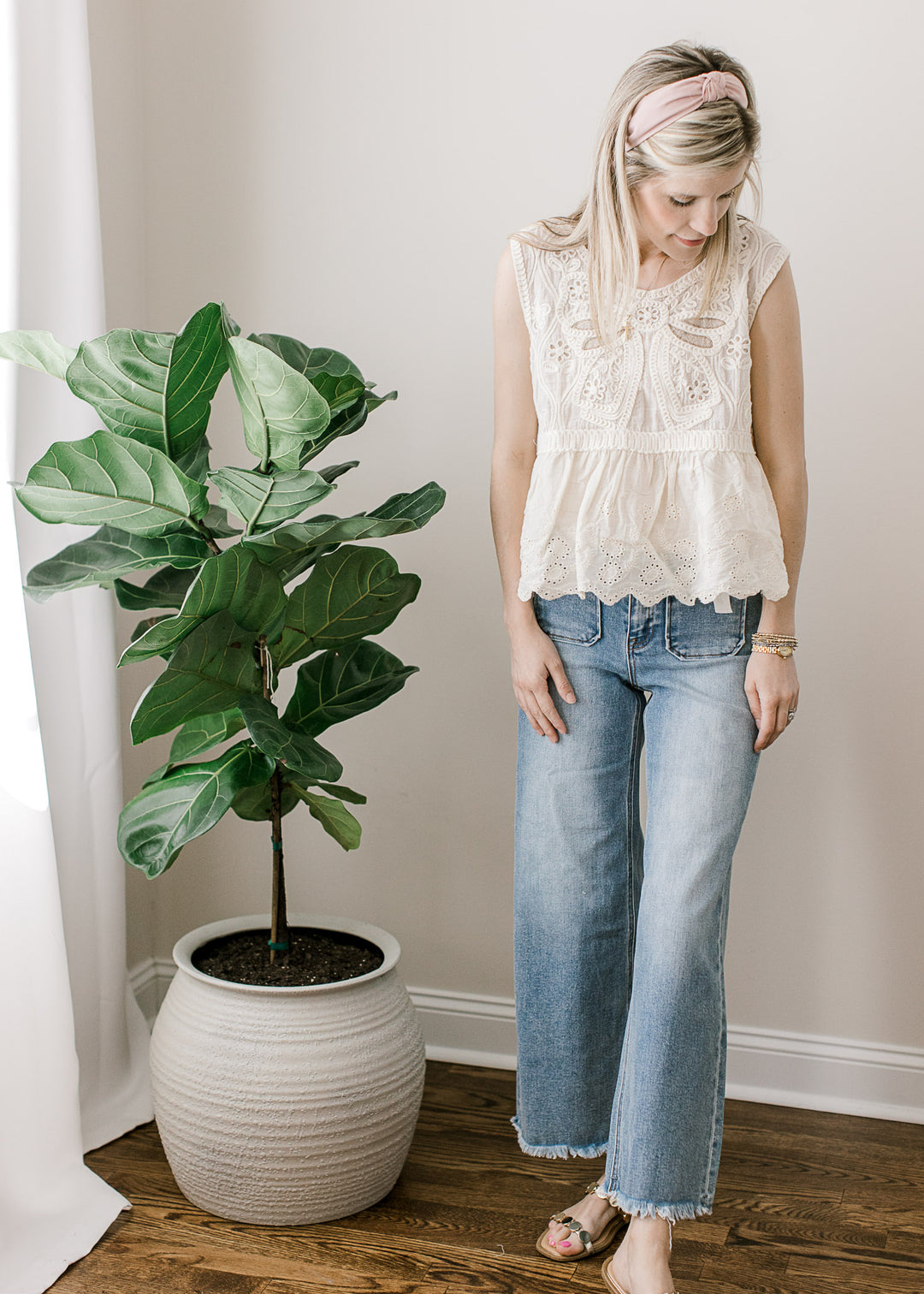 Model wearing a medium/light wash ankle jeans with high rise, wide leg fit with front patch pockets.